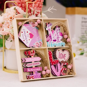 Detail of four pink wooden Valentine's Day heart-themed ornaments in a 4-compartment box