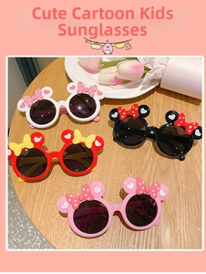 Close-up of cute cartoon bow sunglasses for girls in multiple colors on wooden surface