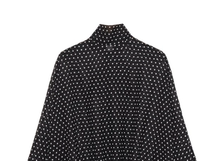 Detail of lightweight black blouse with white polka dots and high neck design texture