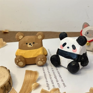 Détail macro de figurines d'ours et panda en bois sculptées à la main avec texture rustique