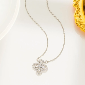 Close-up of a silver titanium steel clover pendant with zircon on a fine link chain