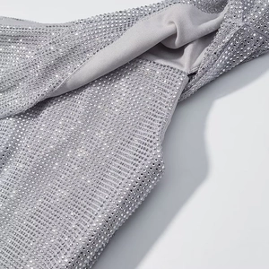 Détail macro de strass argentés étincelants et artisanat délicat sur un tissu gris