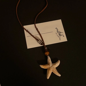 Detail of starfish pendant necklace with wooden beads and adjustable brown cord