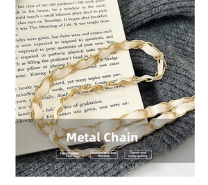 Close-up of elegant gold chain strap with woven white leather on a textured knit background