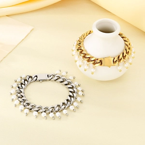 Detail view of gold and silver cuban chain bracelets with multiple pearl charms