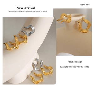 Detail of irregular wave-shaped hoop earrings with 18K gold textured metal finish