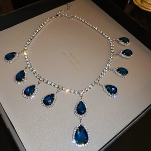 Detailed close-up of luxury necklace featuring ten blue teardrop crystal pendants
