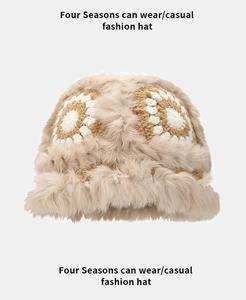 Detail of plush faux fur knit bucket hat featuring white floral pattern embroidery