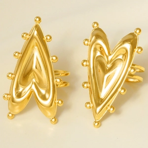 Detailed macro shot of vintage gold heart ring with metal beads on white display base