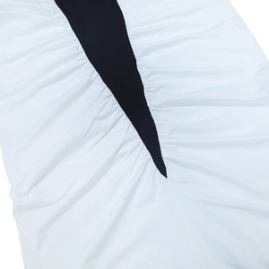Vue détaillée du patchwork noir et blanc avec des plis froncés sur une robe ajustée