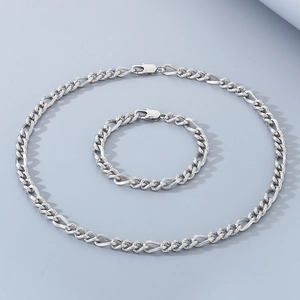 Primo piano del set collana e bracciale a catena Figaro in argento lucido e metallo