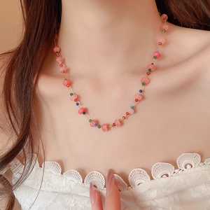 Detail of pink crystal beaded necklace with colorful accents on model collarbone