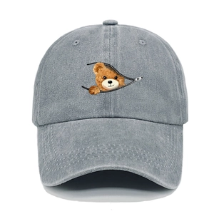 Close-up of cute bear peeking from zipper print on vintage washed grey cotton baseball cap