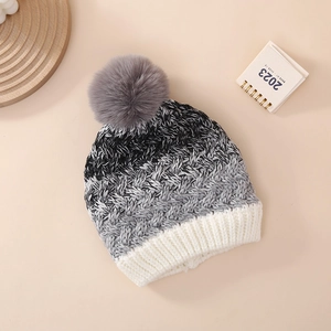 Detailed macro view of the gradient knit beanie texture and soft gray pom-pom detail