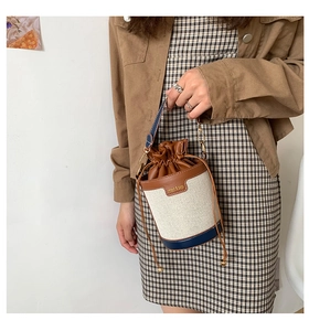 Detail of vintage canvas bucket bag with brown leather drawstring and navy blue trim