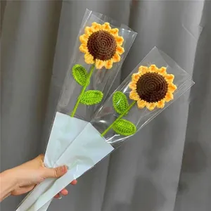 Handmade knitted sunflower bouquet with two yellow flowers in decorative clear packaging
