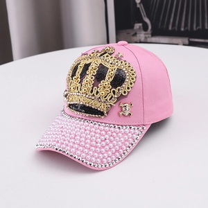 Detail of pink crown baseball cap featuring pearls, golden sequins and rhinestone trim