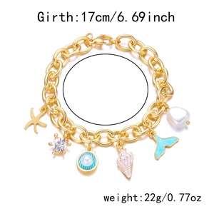 Detail shot of golden ocean charms with starfish shell and pearls on a dainty chain
