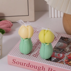 Detalle de velas de tulipán amarillo con cintas de seda sobre un libro en estilo zen