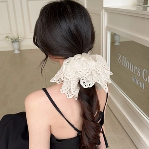 Elegant beige lace scrunchie with intricate floral embroidery shown on a low ponytail