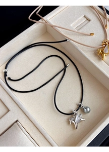 Vue détaillée des pendentifs poney avec perles sur cordons noir et beige en boîte à bijoux