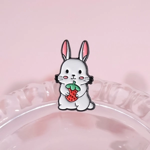 Broche en émail lapin blanc mignon tenant une fraise rouge sur fond rose