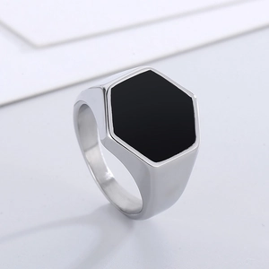 Macro shot of silver stainless steel ring with black hexagonal inlay and polished finish