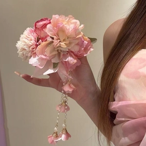 Detailansicht einer eleganten rosa Stoffblumen-Haarspange mit zarten Perlenquasten