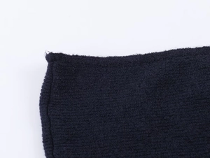 Macro shot of dark blue knit fabric showing detailed stitching and soft fiber texture