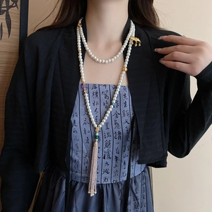 Detail of multi-layer pearl body chain with lotus accents and long elegant tassels