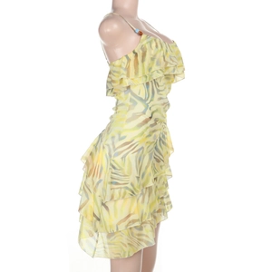 Detailed side view of tiered ruffle dress with yellow-green print and thin straps