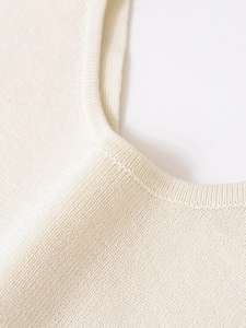Close-up of cream white knitted tank top showing round neck stitching and soft texture