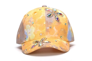 Dettaglio cappello da baseball per bambini in tessuto tie-dye giallo con fiori di strass