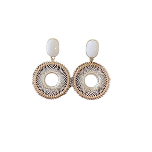 Bohemian geometric hoop earrings with white weave pattern and gold accents on white backdrop