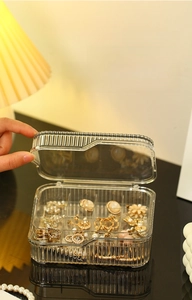 Close-up of clear jewelry box with vertical stripes and dust-proof lid for earrings