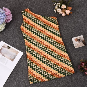 Détail du tissu en maille avec motifs à vagues colorées sur une robe asymétrique
