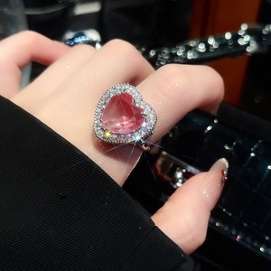 Close-up of sparkling heart-shaped pink zircon ring with adjustable silver-tone band