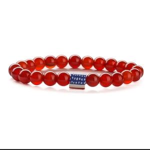 Detailed close-up of red agate beads with a rectangular USA flag charm on elastic cord
