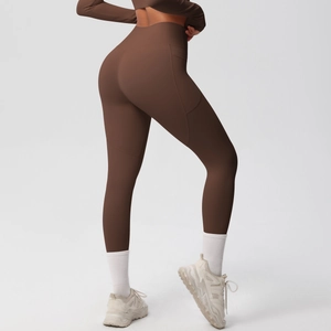 Detail of high-waist dark brown yoga pants with functional side pockets and elastic fabric