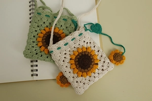 Detail of hand-knitted sunflower crossbody bags in green and beige crochet patterns