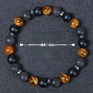Macro view of 8mm tiger eye, matte onyx and lava stone beads with Strength text overlay
