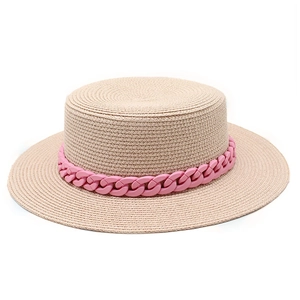 Detail of pink matte chain decoration on flat-top woven straw sun hat for beach