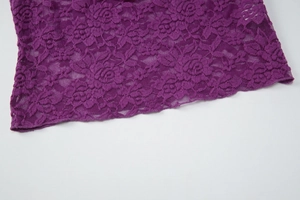 Détail rapproché de la dentelle florale violette sur ce haut d'été sexy avec col en V