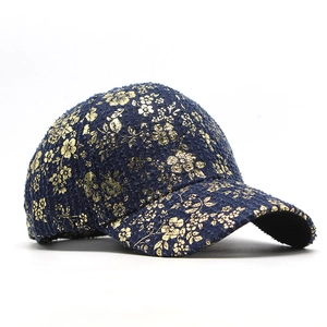Detailed macro of vintage denim baseball cap with gold floral foil and tweed texture