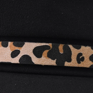 Macro detail of black twill fabric featuring a velvet leopard print chain decoration