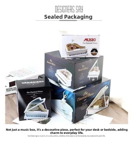 Close-up of stacked piano music box packaging in blue, black, and white colors