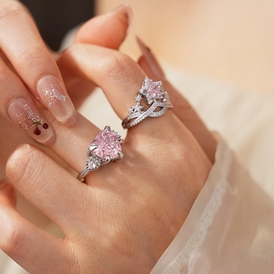 Detail of silver heart and star rings with pink zircons worn on a finger