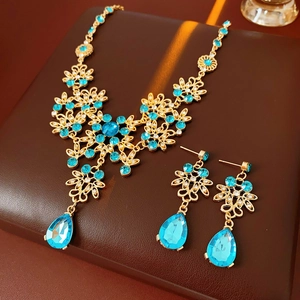 Detail of vintage gold filigree jewelry set with blue zircon teardrop pendants