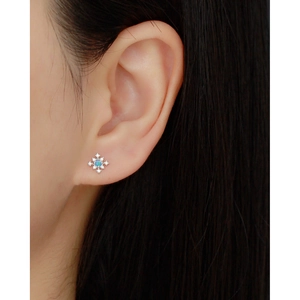 Close-up of s925 silver snowflake earring with blue opal and diamonds on a model