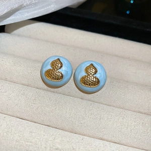 Macro shot of light blue acrylic round stud earrings with golden hulu gourd emblem